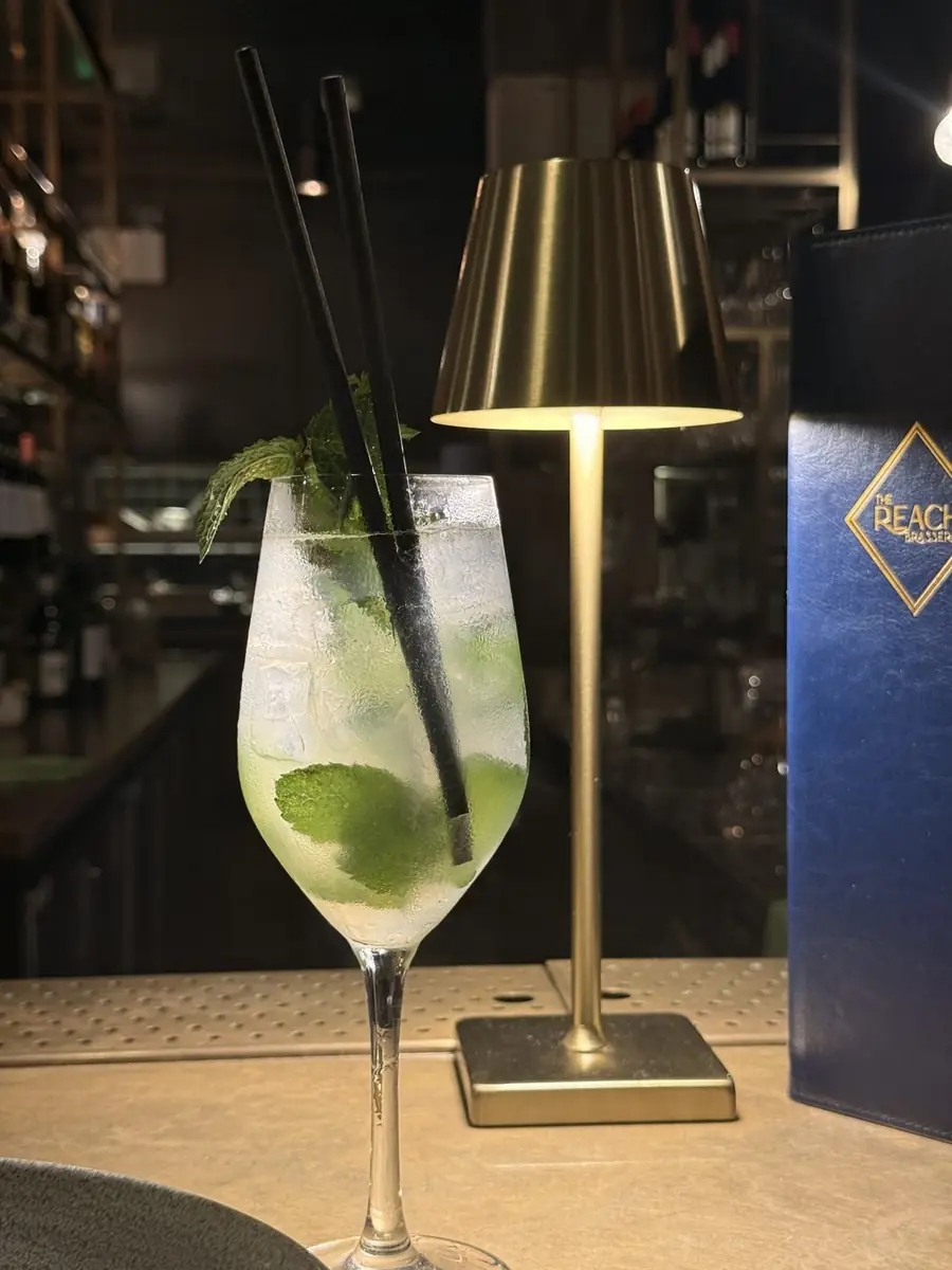 A mojito beside a brass table lamp