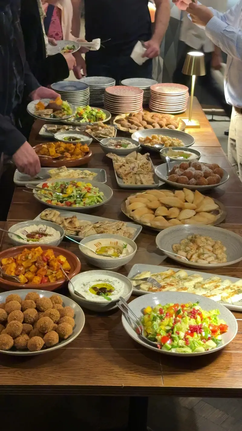 Sharing plates laid out on a long table for a group dinner at The Reach Riverside